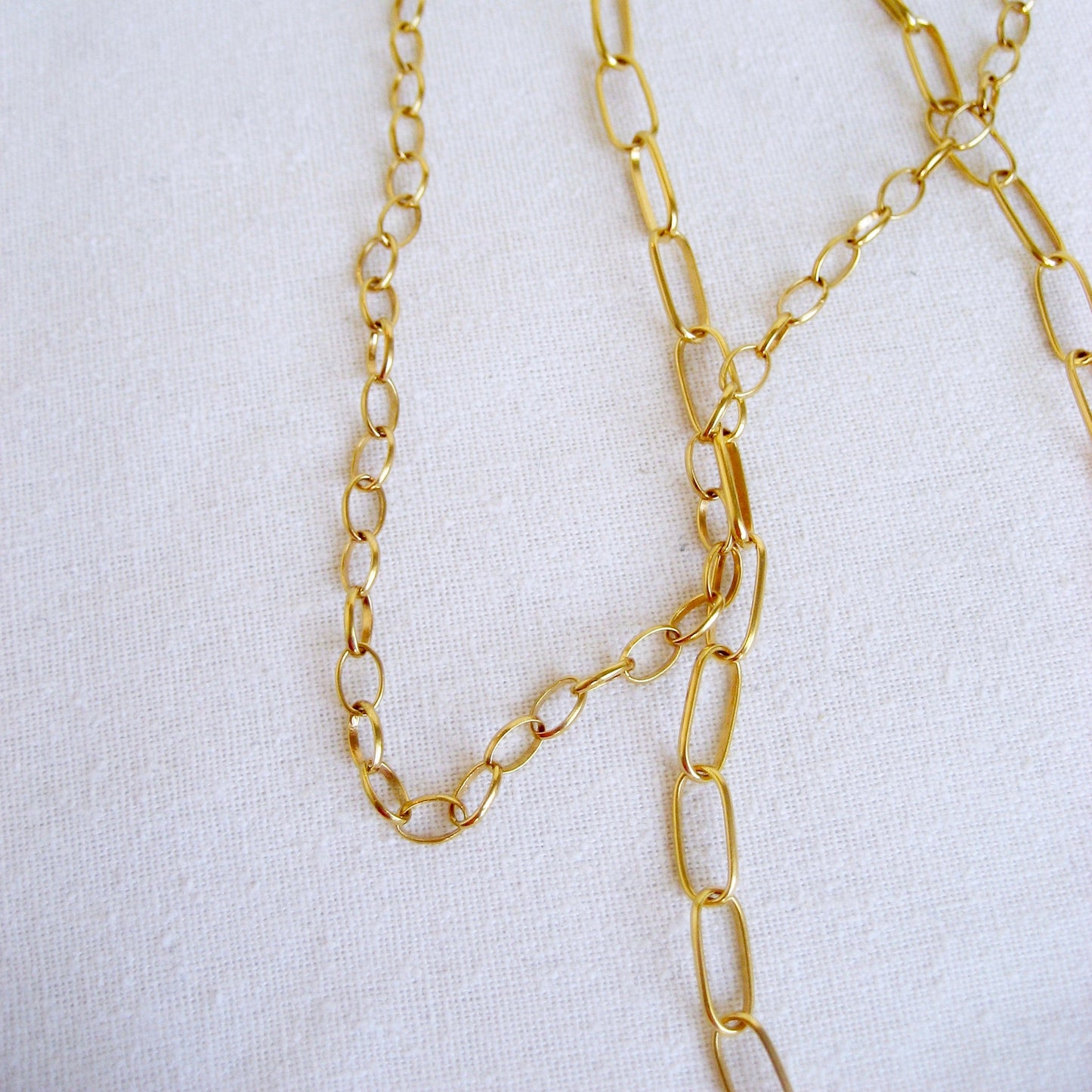 This 18k small oval cable is shown with the larger oval cable chain variation draped together.