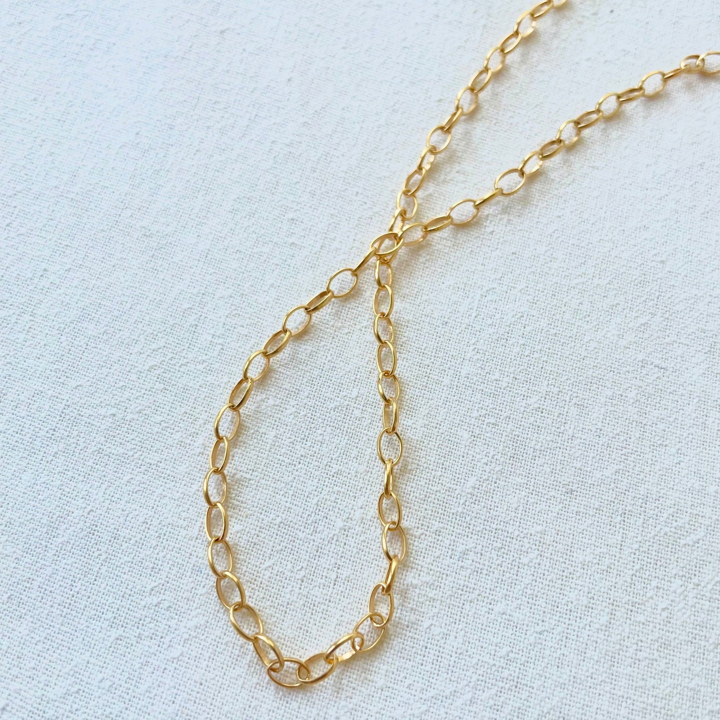 photo of a draped 18k yellow gold oval cable paperclip in satin finish 18 inch length