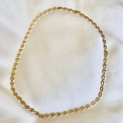 18k Gold puffy mariner chain necklace on a white fabric background solid link construction
